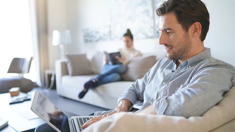 Man with computer and woman in background